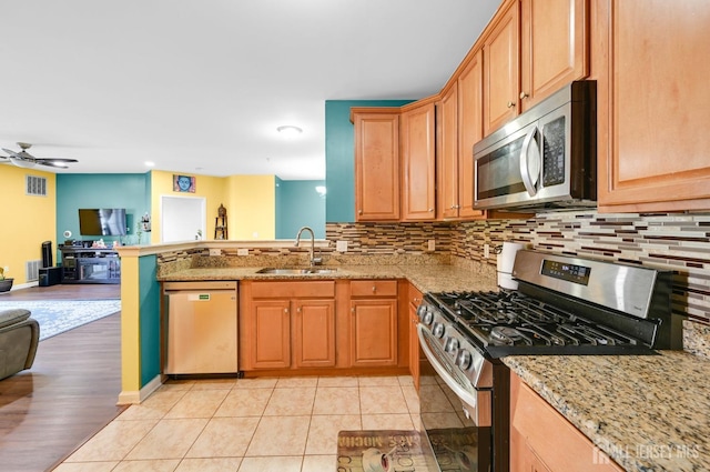 2022 Edward Stec Blvd, Edison, NJ 08837 - kitchen with appliances with stainless steel finishes, open floor plan, a sink, a peninsula, and tasteful backsplash