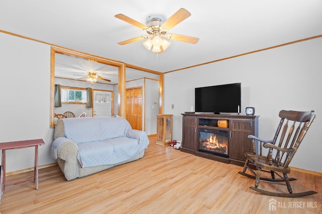 75 Princeton Rd, Old Bridge, NJ 08859 - living area featuring ceiling fan, wood finished floors, a glass covered fireplace, baseboards, and crown molding