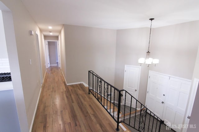 6 Joan St, South Brunswick, NJ 08824 - hallway with a chandelier, baseboards, wood finished floors, and an upstairs landing