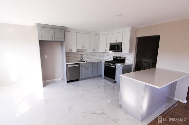 6 Joan St, South Brunswick, NJ 08824 - kitchen with a sink, gray cabinets, backsplash, light countertops, and appliances with stainless steel finishes
