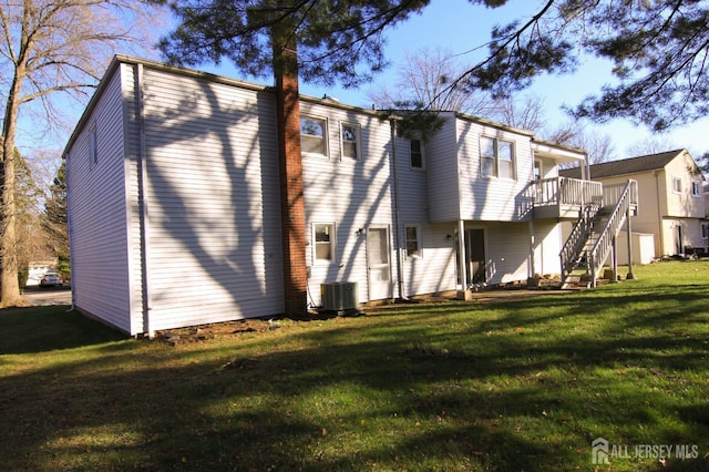 6 Joan St, South Brunswick, NJ 08824 - rear view of property featuring a deck, a chimney, stairs, central AC unit, and a lawn