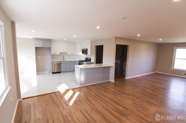 6 Joan St, South Brunswick, NJ 08824 - kitchen with stainless steel appliances, light wood finished floors, gray cabinets, and baseboards