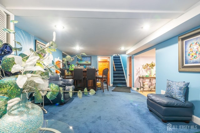 carpeted living area with stairs