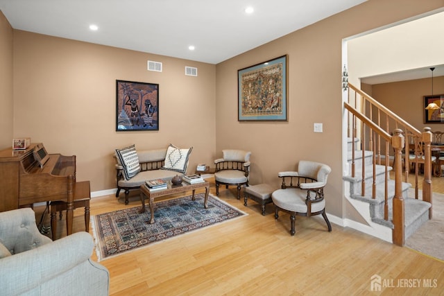 sitting room featuring recessed lighting, wood finished floors, visible vents, and stairs
