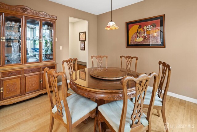 dining area featuring baseboards and light wood-type flooring