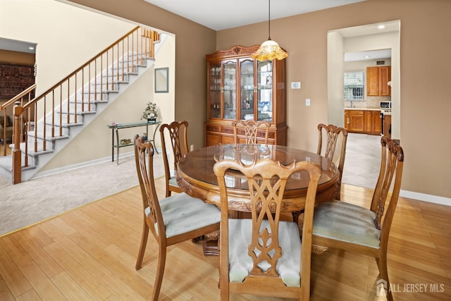 dining room featuring recessed lighting, stairway, baseboards, and light wood-type flooring