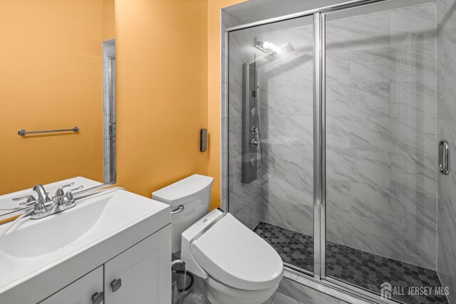 bathroom with vanity, toilet, and a stall shower