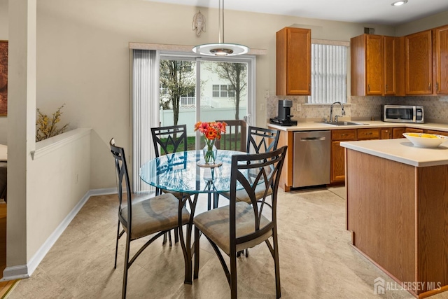 kitchen with light countertops, tasteful backsplash, stainless steel appliances, and a sink
