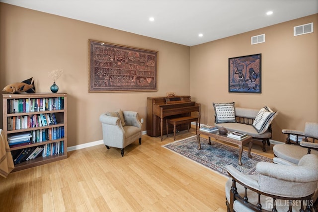 living area with recessed lighting, wood finished floors, and visible vents