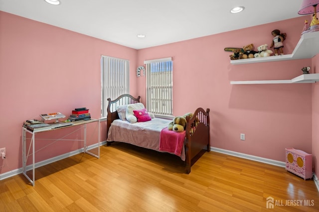 bedroom with baseboards, wood finished floors, and recessed lighting