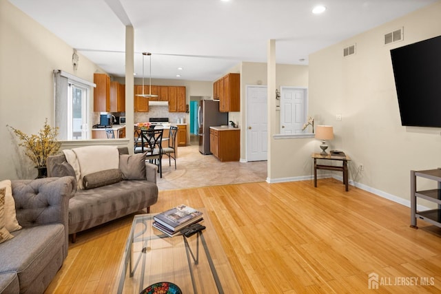 living area featuring recessed lighting, light wood-style flooring, visible vents, and baseboards