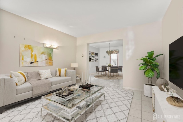 living room featuring a chandelier, baseboards, and light tile patterned floors