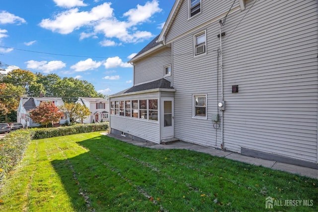 view of property exterior with a sunroom and a yard