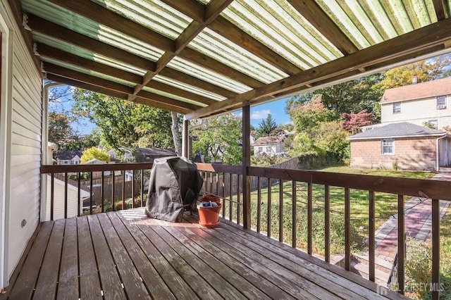 wooden deck featuring grilling area and an outdoor structure