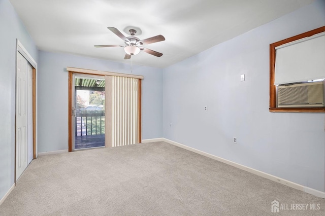 carpeted empty room with ceiling fan, baseboards, and cooling unit