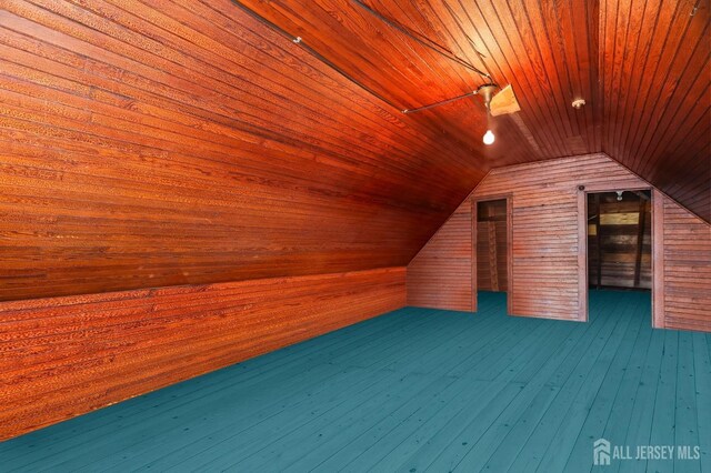 additional living space featuring wooden walls, wooden ceiling, lofted ceiling, and hardwood / wood-style floors