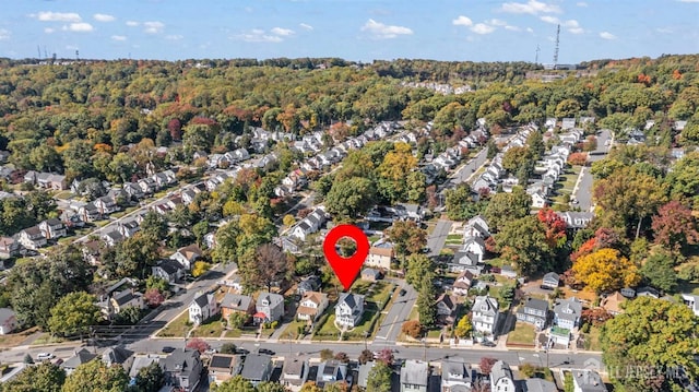 aerial overview of property's location featuring nearby suburban area and a forest