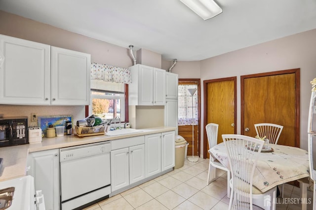 kitchen with black microwave, white dishwasher, a sink, white cabinetry, and light countertops