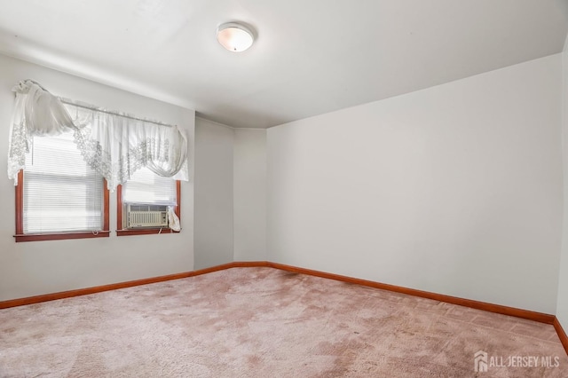 carpeted spare room featuring baseboards