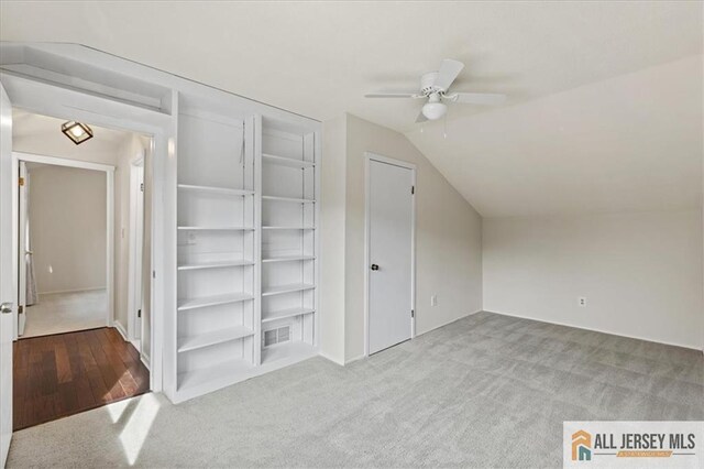additional living space with vaulted ceiling, ceiling fan, carpet flooring, and visible vents