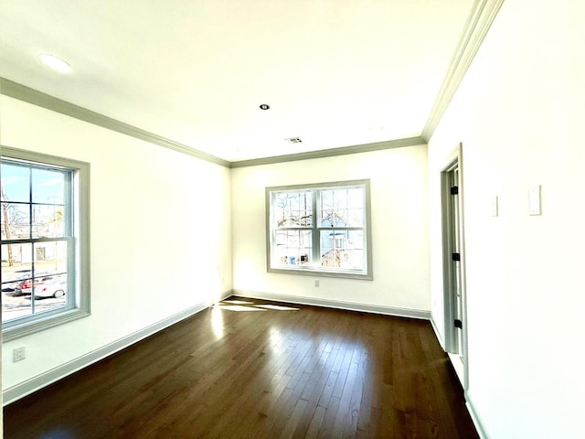 unfurnished room with dark wood-type flooring, plenty of natural light, crown molding, and baseboards