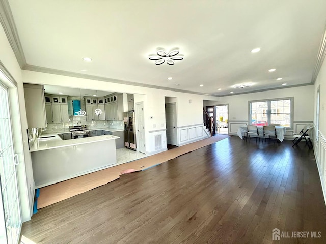 47 Bird Ave, Iselin, NJ 08830 - kitchen featuring ornamental molding, appliances with stainless steel finishes, a sink, hardwood / wood-style flooring, and open floor plan