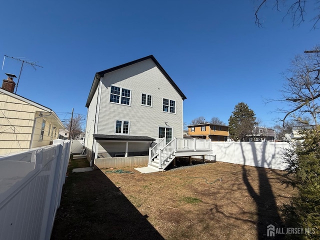 back of property featuring stairs, a fenced backyard, and a deck