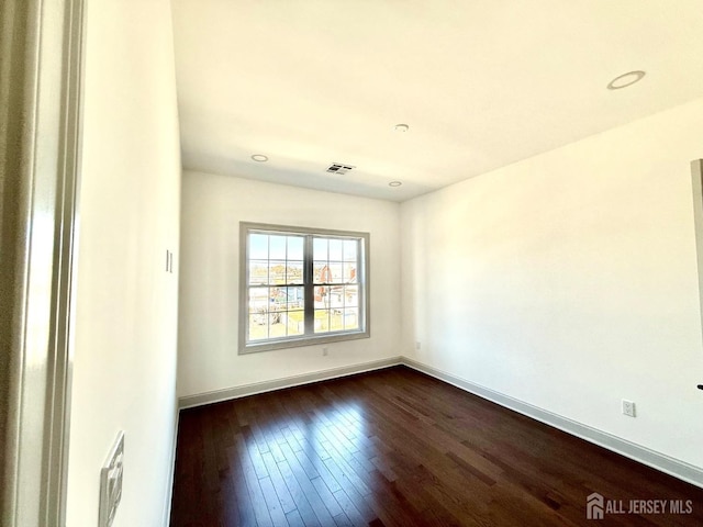 unfurnished room featuring recessed lighting, baseboards, visible vents, and dark wood-style floors