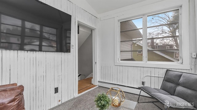 living area with carpet, a baseboard heating unit, and vaulted ceiling