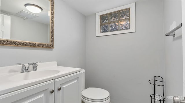 bathroom featuring toilet, visible vents, and vanity