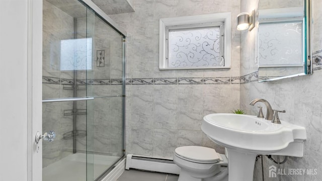 full bathroom with toilet, a baseboard radiator, tile walls, and a shower stall