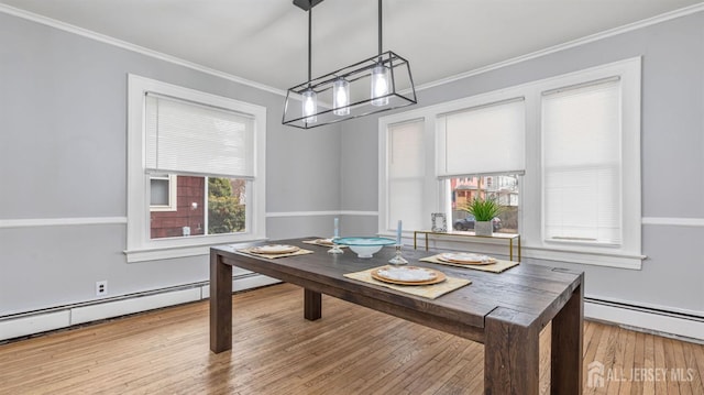 dining area with a baseboard radiator, wood finished floors, and crown molding