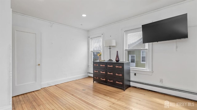 bedroom with baseboards, recessed lighting, a baseboard radiator, and light wood-style floors