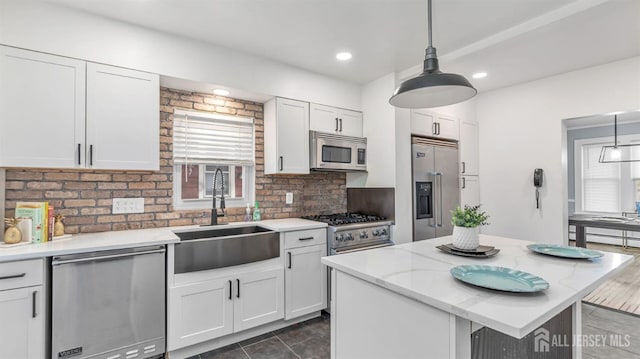 kitchen with white cabinets, a sink, decorative backsplash, and high quality appliances