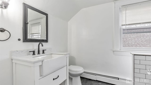 bathroom featuring toilet, plenty of natural light, a baseboard heating unit, and vaulted ceiling