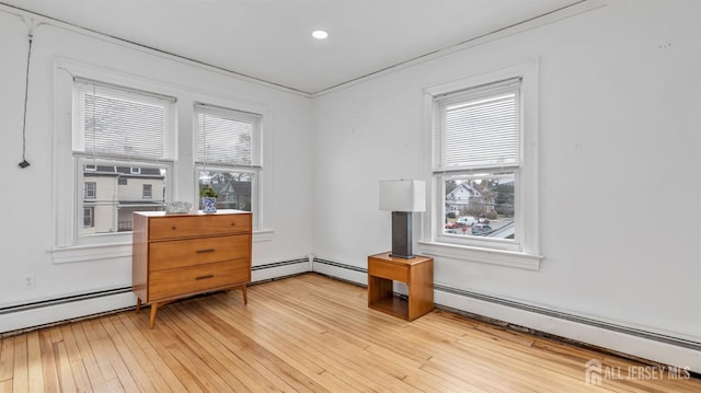 interior space with a baseboard radiator, light wood finished floors, plenty of natural light, and recessed lighting