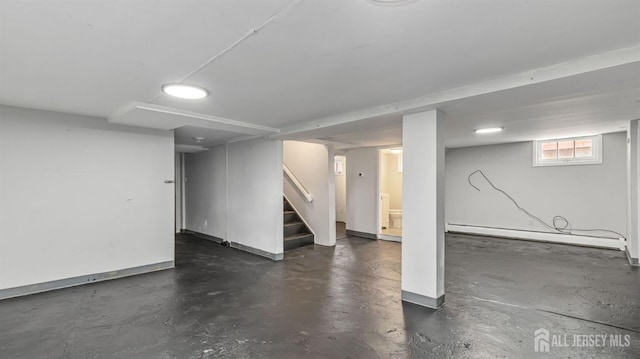 basement featuring stairway and baseboard heating