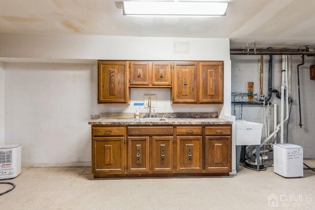 kitchen with light countertops, brown cabinets, and a sink