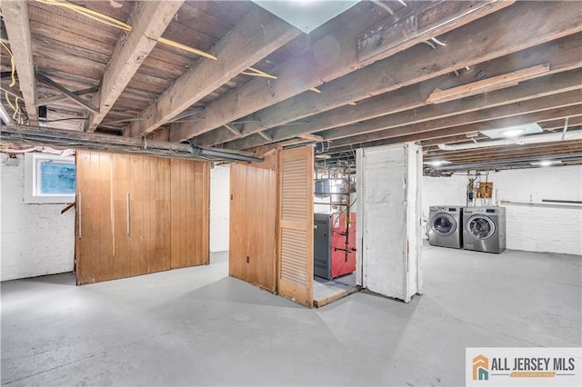 basement with heating unit and washing machine and dryer