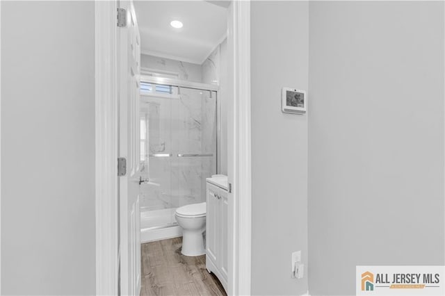 full bath with recessed lighting, a marble finish shower, toilet, and wood finished floors