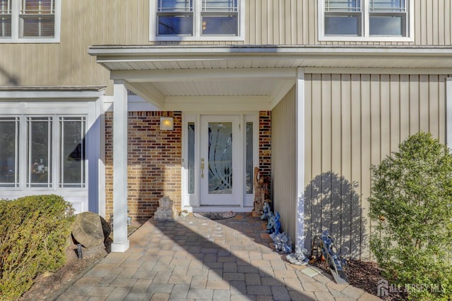 entrance to property featuring brick siding and board and batten siding