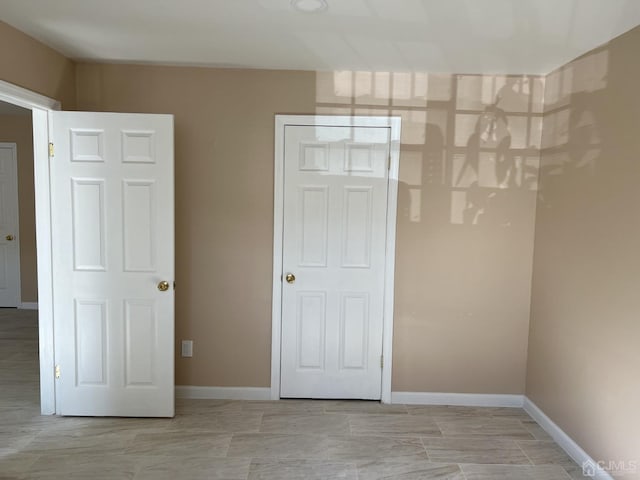 unfurnished room with baseboards