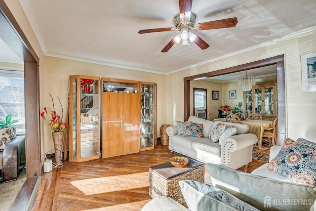 living room with ornamental molding, wood finished floors, a ceiling fan, and a healthy amount of sunlight