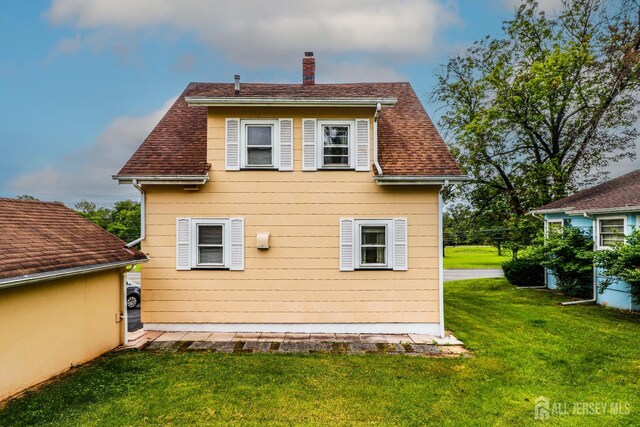 1107 River Rd, Piscataway, NJ 08854 - back of house with a chimney, a lawn, and a shingled roof