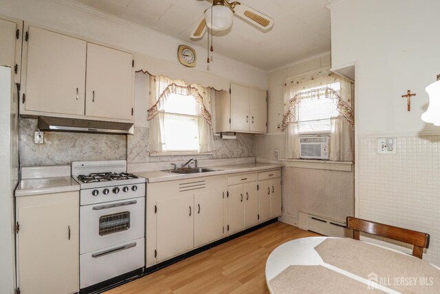 1107 River Rd, Piscataway, NJ 08854 - kitchen with white range with gas cooktop, a sink, baseboard heating, a ceiling fan, and light countertops
