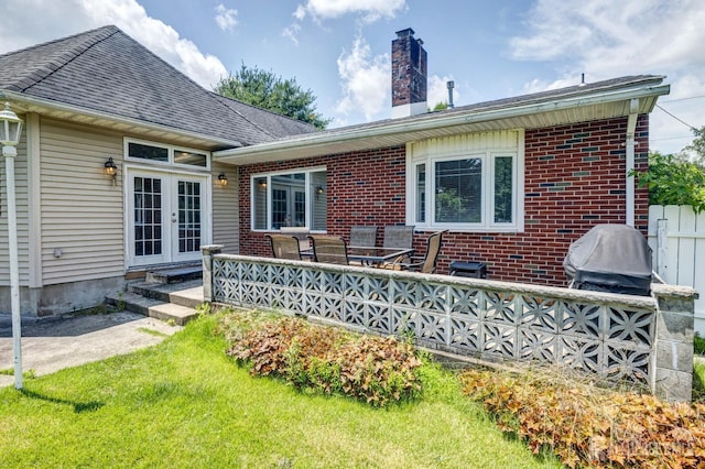 294 Fresh Pond Rd, South Brunswick, NJ 08902 - rear view of house featuring a chimney, brick siding, french doors, and a lawn