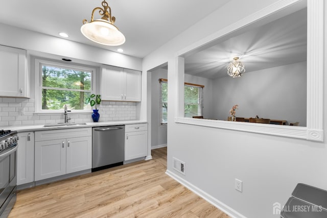 45 Kenmore Rd, Edison, NJ 08817 - kitchen featuring appliances with stainless steel finishes, tasteful backsplash, light countertops, light wood-type flooring, and plenty of natural light