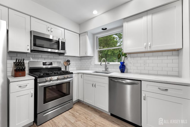 45 Kenmore Rd, Edison, NJ 08817 - kitchen featuring stainless steel appliances, white cabinets, light wood finished floors, tasteful backsplash, and light stone countertops