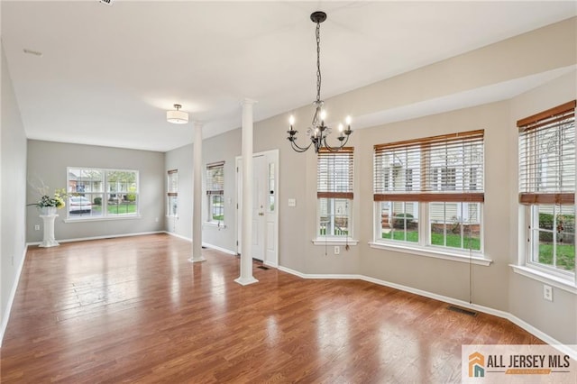 1115 Joseph Ct, South Plainfield, NJ 07080 - unfurnished dining area with decorative columns, healthy amount of natural light, and wood finished floors