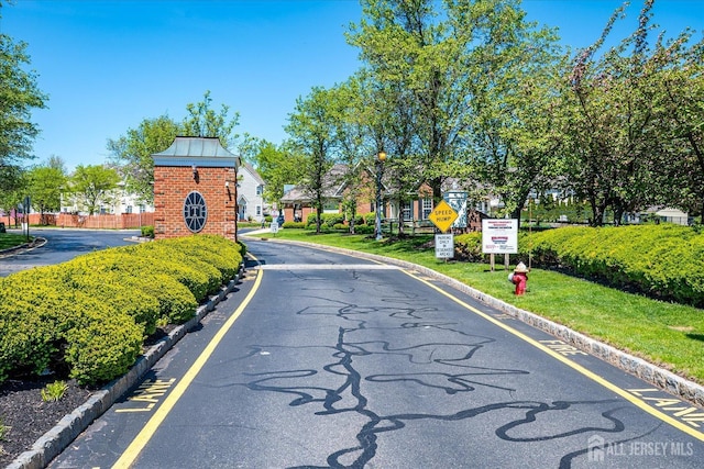 822 Dominick Ct, South Plainfield, NJ 07080 - view of asphalt street featuring street lighting, curbs, traffic signs, and a gated entry